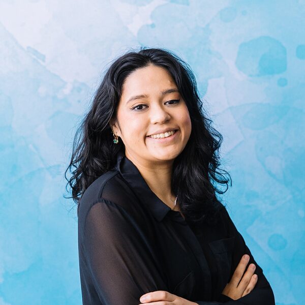 Image of smiling young female recruitment consultant in black blouse and dark features,