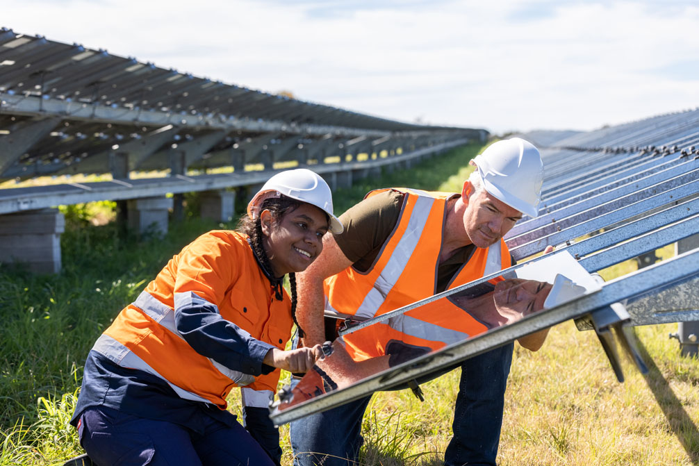 Aboriginal lady and man installing solar panels in the Hunter