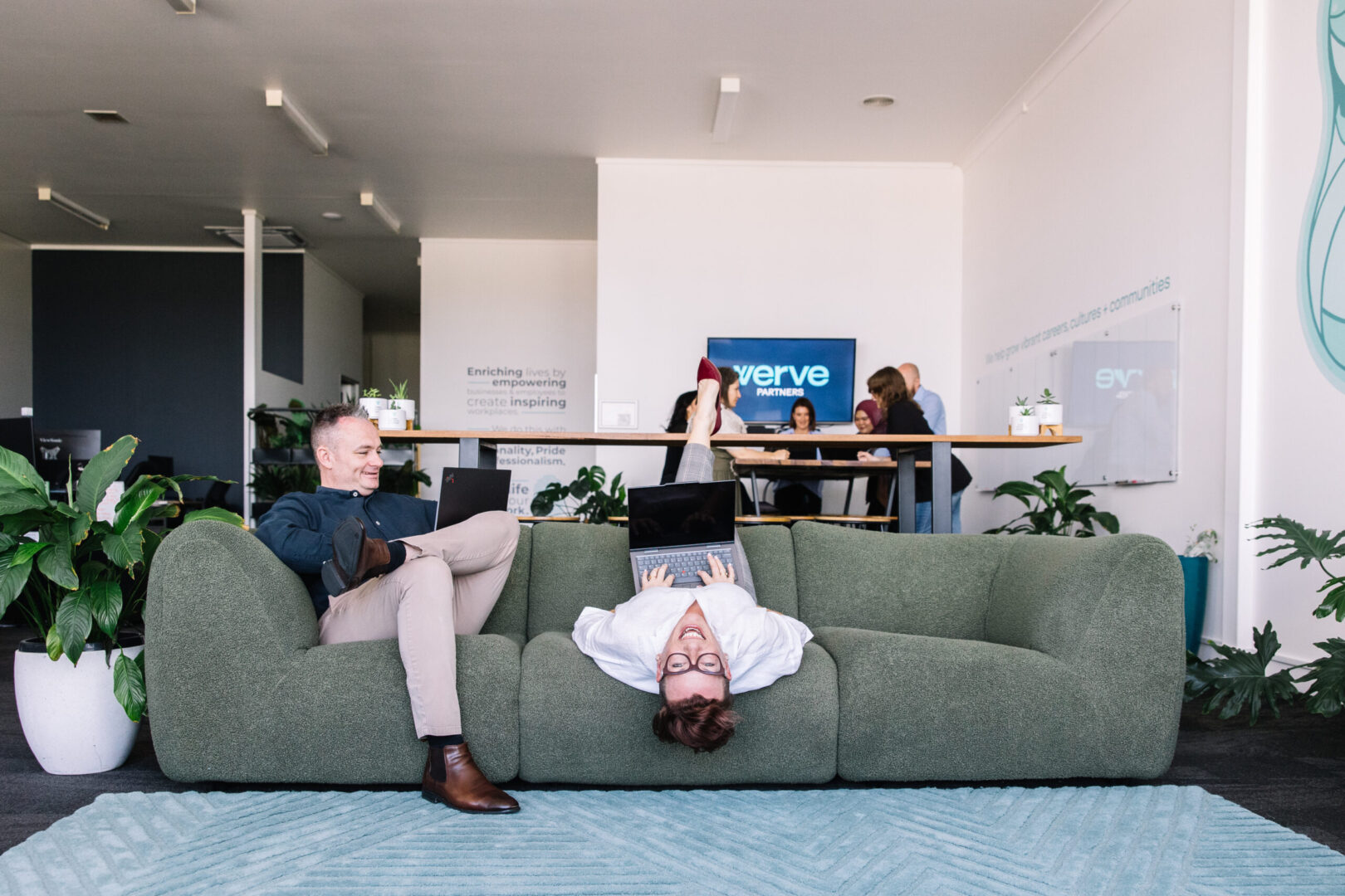 Funny photo of CEO having fun upside down on lounge office chair, executive director having a laugh together | Recruitment Agency Newcastle