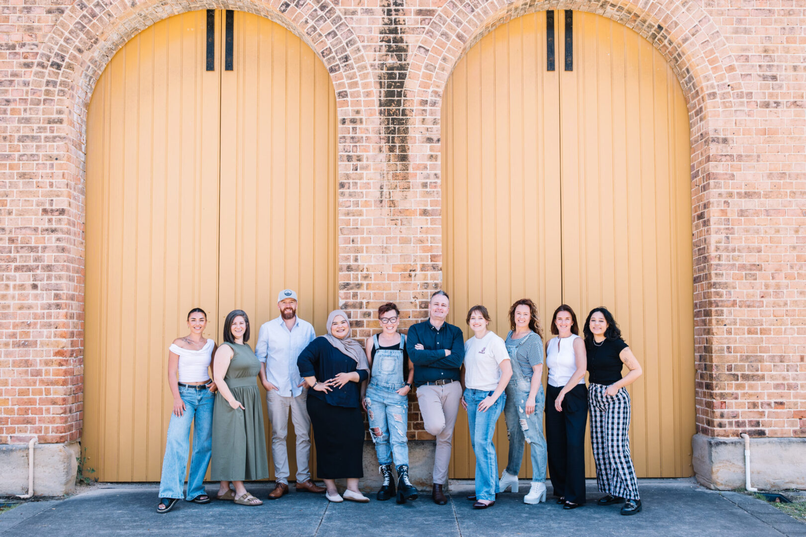 image of verve partners recruitment team standing in front of big yellow doors, outside in newcastle CBD