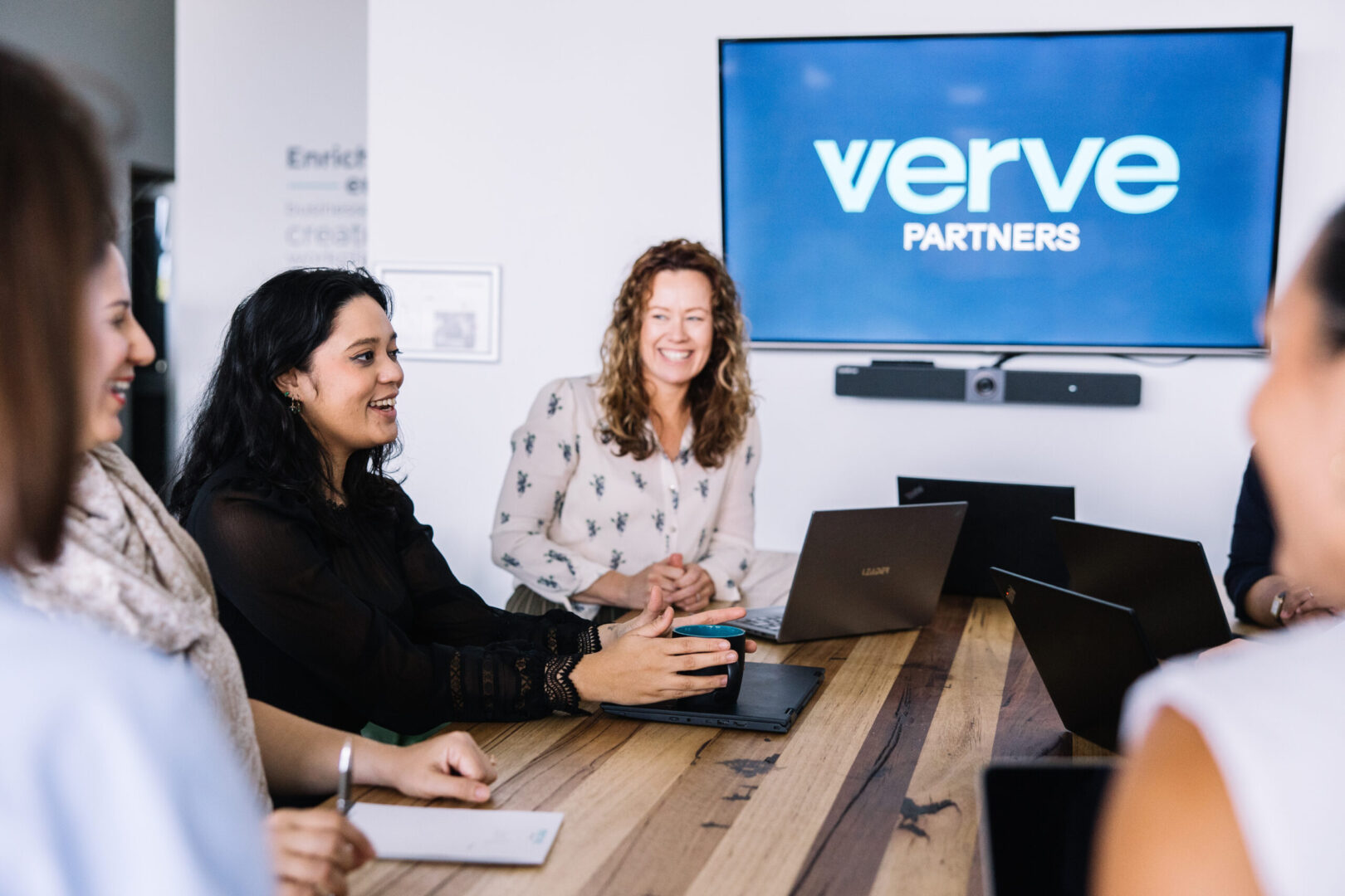 Verve Partners Team Gathered around a standing meeting table in the office in hamilton, newcastle