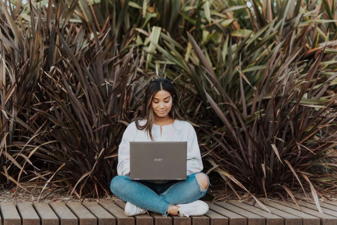 Lady sitting in nature wanting to understand how to help young employees succeed remotely