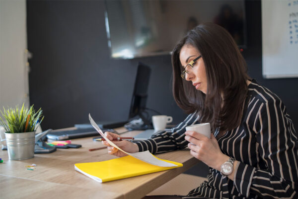 Recruiter reviewing candidate notes and preparing interview questions at her desk
